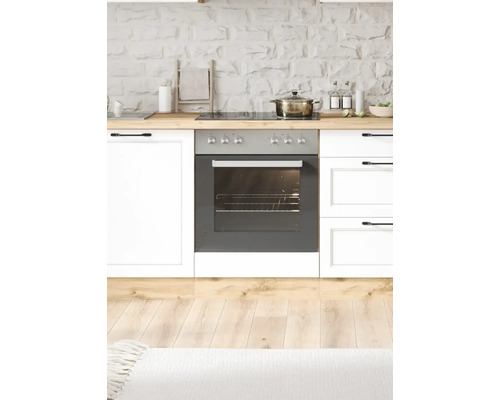 Küchenszene mit Herd, Backofen und Küchenutensilien auf einer Holzarbeitsplatte vor einer Steinwand