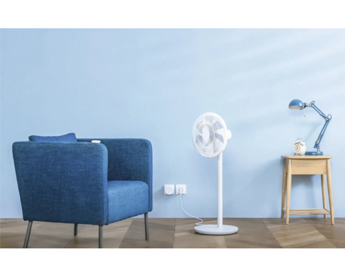 Wohnzimmerszene mit Sessel, Ventilator, Nachttischlampe und Wecker