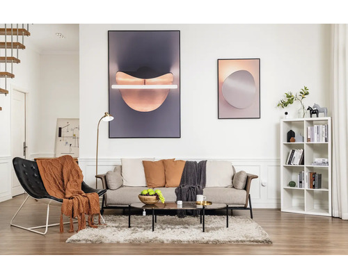 Wohnzimmer mit Sofa, Sessel, Couchtisch, Bücherregal und Dekoration