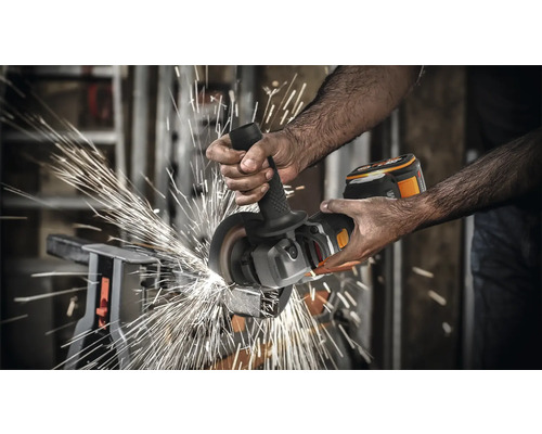 Eine Person verwendet einen Akku-Winkelschleifer zum Schneiden von Metall, wobei Funken sprühen.