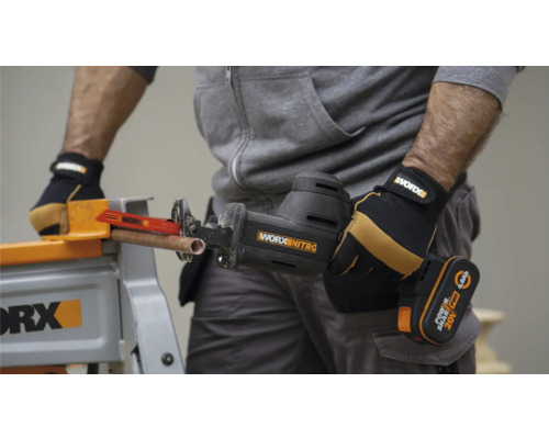 Akkubetriebene Säbelsäge schneidet Kupferrohr auf Werkbank