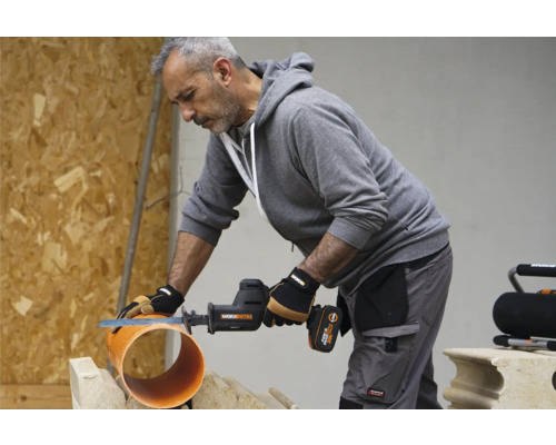 Handwerker sägt mit einer Akku-Säbelsäge ein Rohr