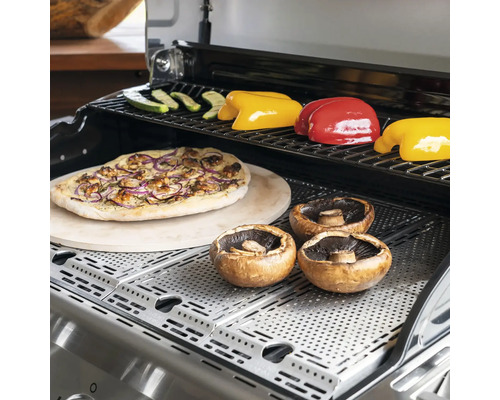 Grill mit Pizza, Champignons, Paprika und Zucchini auf dem Rost.
