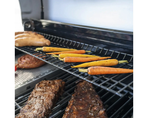 Verschiedene Speisen wie Karotten, Würste und Fleisch auf einem Grill.