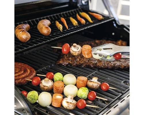 Grill mit Würstchen, Gemüse und Fleisch auf dem Rost
