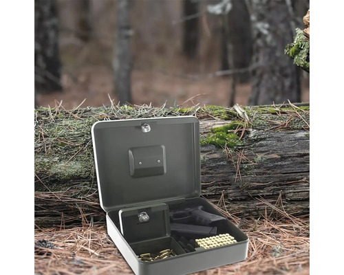 Geöffneter Waffenkoffer mit Munition und Pistole im Wald