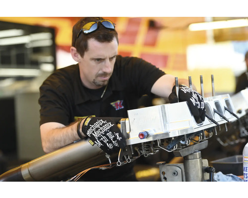 Ein Mechaniker arbeitet an einem Motorteil.
