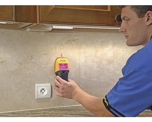 Mann benutzt Wandscanner in Küche zur Objekterkennung