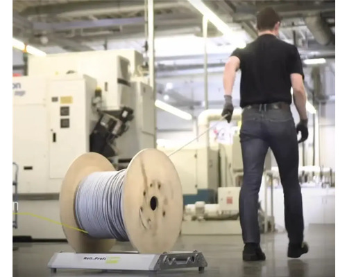 Kabeltrommel mit Kabel auf Rollenbock mit einer Person