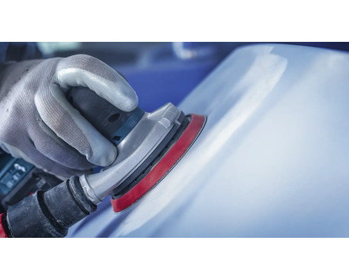 Hand mit Schutzhandschuh beim Schleifen einer Oberfläche mit einem Exzenterschleifer