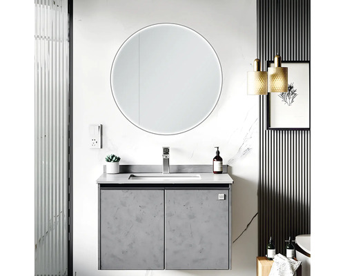 Modernes Badezimmer mit Waschtisch, rundem Spiegel mit Beleuchtung und dekorativen Elementen.