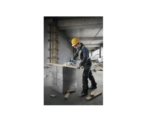 Ein Handwerker mit Schutzhelm sägt ein Holzbrett mit einer Kreissäge.