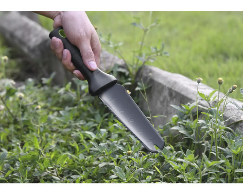 Hand hält Gartenmesser zum Jäten von Unkraut.