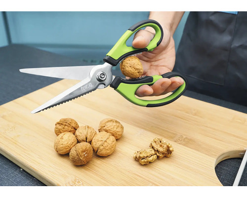 Nussknacker-Schere zum Öffnen einer Walnuss auf einem Schneidebrett