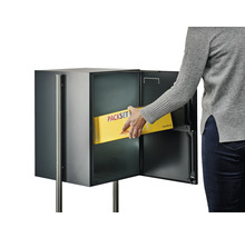 Person legt ein Paket in einen Paketkasten