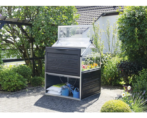 Gewächshaus mit Pflanztisch und Aufbewahrung im Garten.