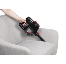 Akkusauger bei der Reinigung eines Sessels.