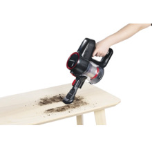 Akkusauger in Verwendung auf einem Holztisch zur Reinigung von Schmutz