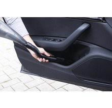 Handstaubsauger im Einsatz zur Reinigung der Autotürablage