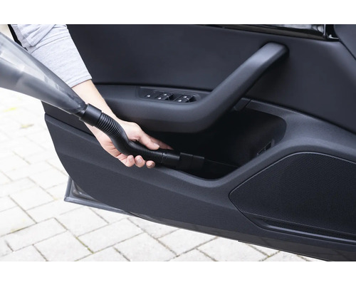 Handstaubsauger im Einsatz zur Reinigung der Autotürablage