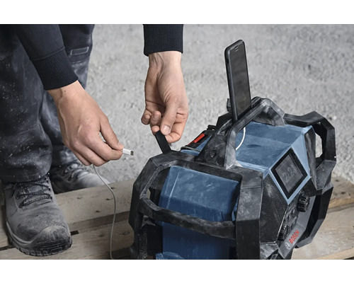 Baustellenradio mit USB-Ladekabel und Smartphone