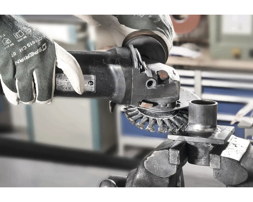 Drahtbürste im Einsatz mit Winkelschleifer zum Entrosten eines Werkstücks im Schraubstock