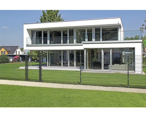 Modernes Haus mit Doppelstabmattenzaun umgeben von Rasenfläche