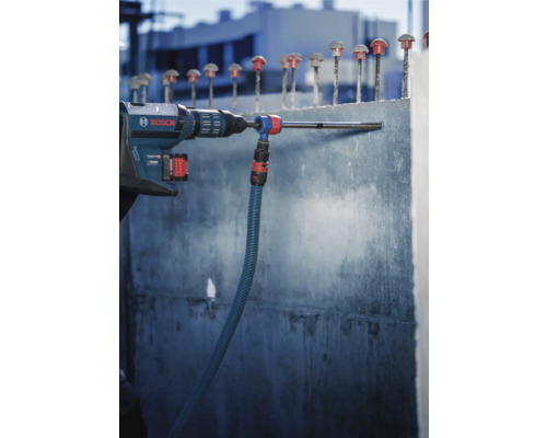 Bosch Bohrhammer beim Bohren eines Lochs in eine Betonwand mit Staubsaugeraufsatz