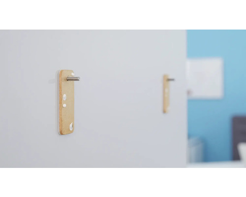 Zwei an einer Wand befestigte Möbelverbinder mit Schrauben