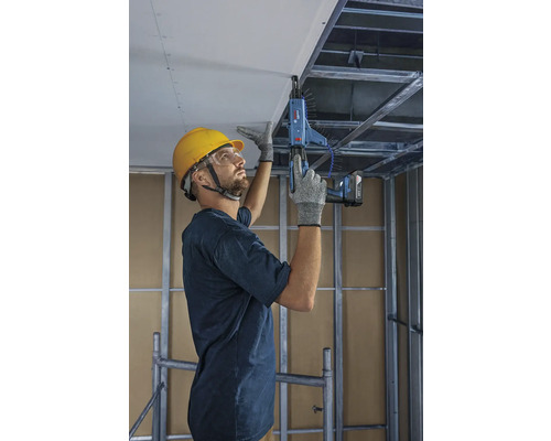 Handwerker befestigt Deckenplatten mit einem Magazinschrauber