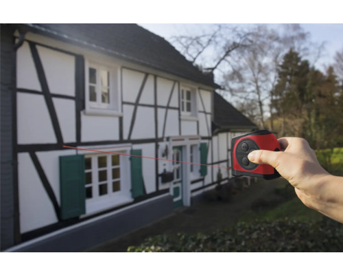 Hand verwendet einen Laser Entfernungsmesser an einem Fachwerkhaus