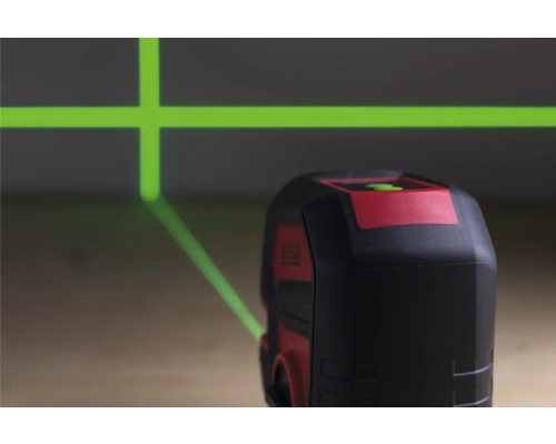 Kreuzlinienlaser projiziert grüne Laserlinien an die Wand.
