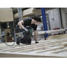 Handwerker befestigt Holzlatten mit einem Druckluftnagler
