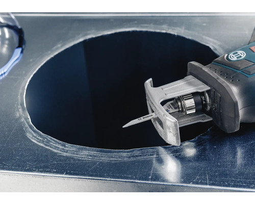 Eine Stichsäge schneidet ein Loch in ein Metallblech.