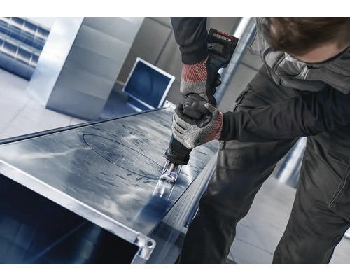 Handwerker schneidet mit einer Blechschere ein Metallblech.