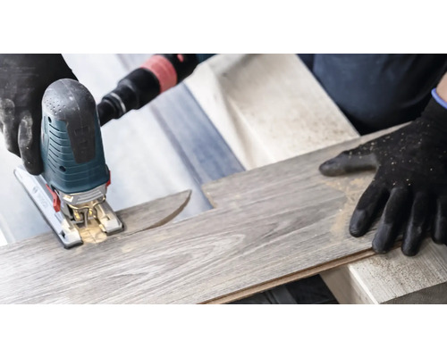 Eine Stichsäge schneidet ein Laminatbrett.