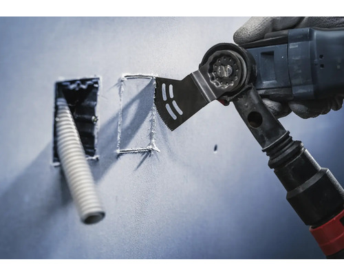 Multifunktionswerkzeug schneidet eine Öffnung in eine Wand für ein Leerrohr