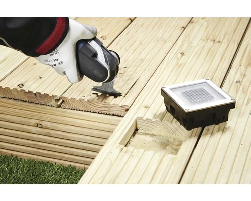 Installation einer Terrassenbeleuchtung in Holzdielen mit einer Säge