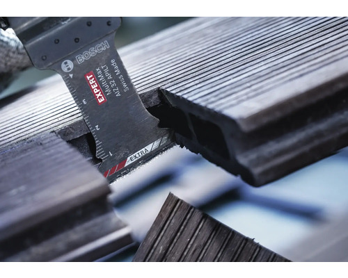 Bosch Logo. Nahaufnahme einer Säge beim Schneiden eines Terrassenbretts.