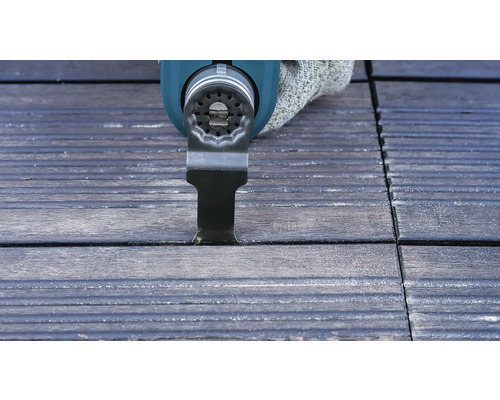 Oszillierendes Elektrowerkzeug schneidet eine Fuge in Terrassendielen