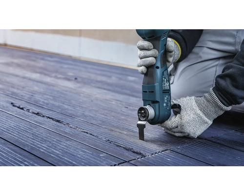 Oszillierendes Elektrowerkzeug im Einsatz auf Holzterrasse