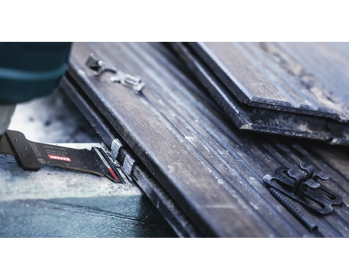 Detailaufnahme eines Sägeblatts beim Sägen von Dachziegeln mit Befestigungsclips