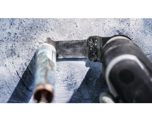 Multifunktionswerkzeug mit Metallsägeblatt schneidet ein Metallrohr