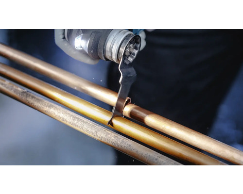 Mehrzweckwerkzeug beim Schneiden eines Kupferrohrs