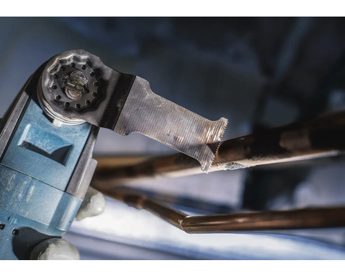 Oszillierendes Elektrowerkzeug schneidet ein Kupferrohr.