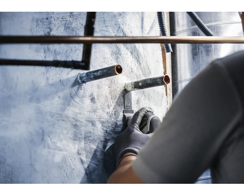 Installation von Kupferrohren an einer Wand durch einen Handwerker.