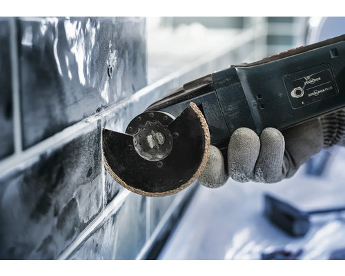 Nahaufnahme eines Multitools beim Schneiden von Fliesen