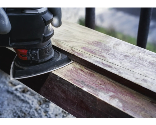 Dreieckschleifer beim Schleifen eines Holzstücks