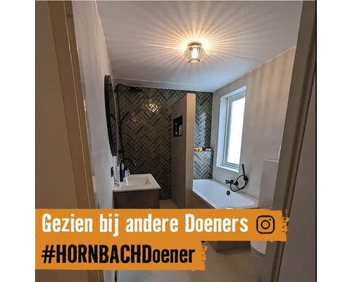 Helles Badezimmer mit Badewanne, Waschbecken und Wandfliesen im Fischgrätenmuster