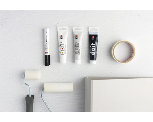 Farbstifte, Farbtuben, Farbroller und Malerkrepp auf hellem Untergrund